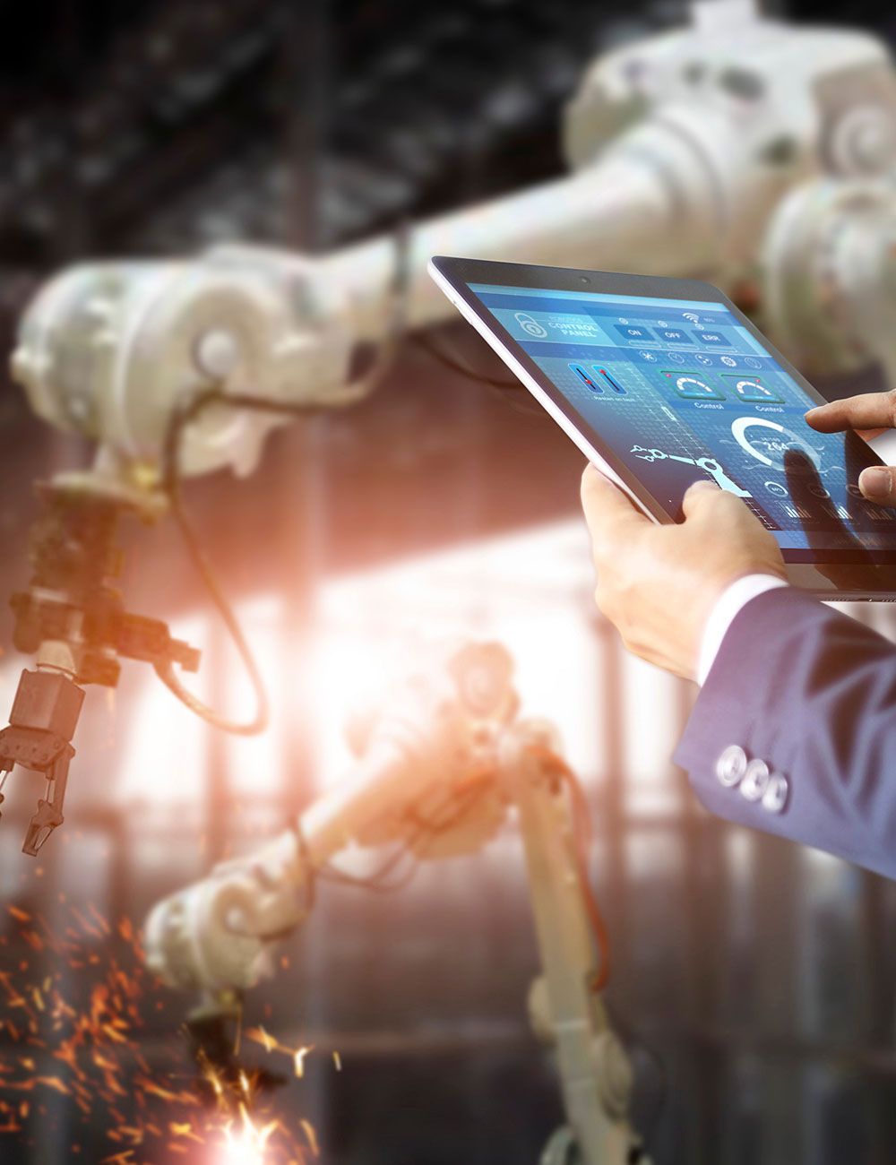 Ein Mitarbeiter überprüft die Funktion eines Roboterarms mit Hilfe eines Tablets